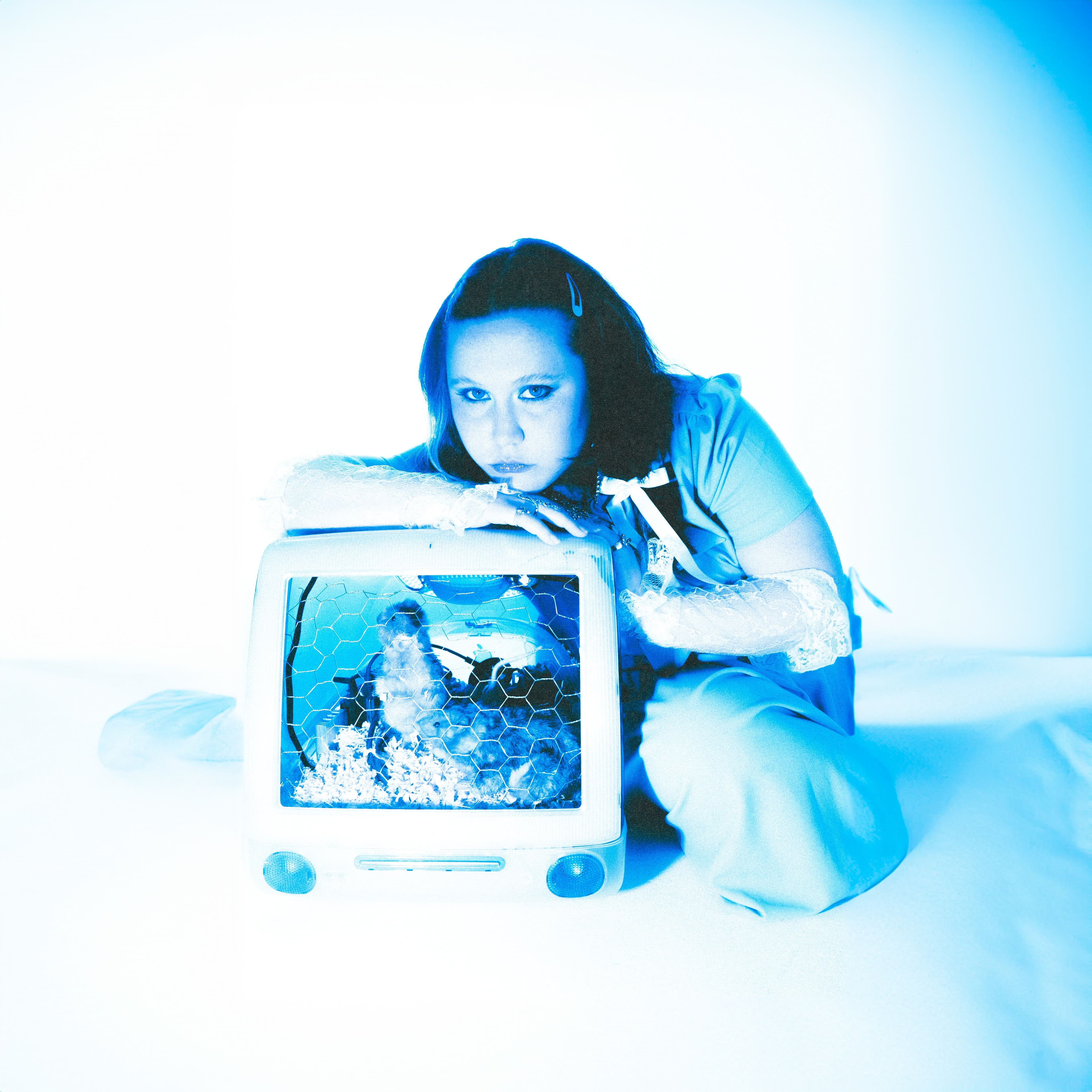 Singer Penelope Scott sitting on the ground next to a computer